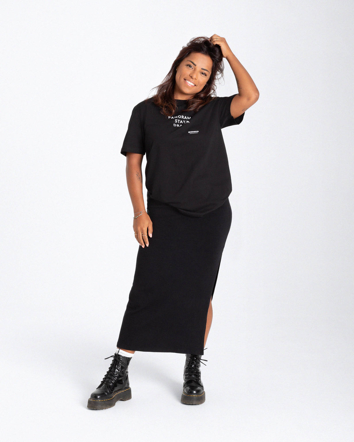 Ein weibliches Model trägt ein schwarzes T-Shirt mit einem weißen "PANORAMA STATT DRAMA" Schriftzug auf der Brust.