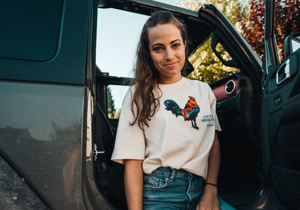Junge Dame trägt Can you Hendl this T-Shirt von Strawanza und sitzt in einem Jeep.