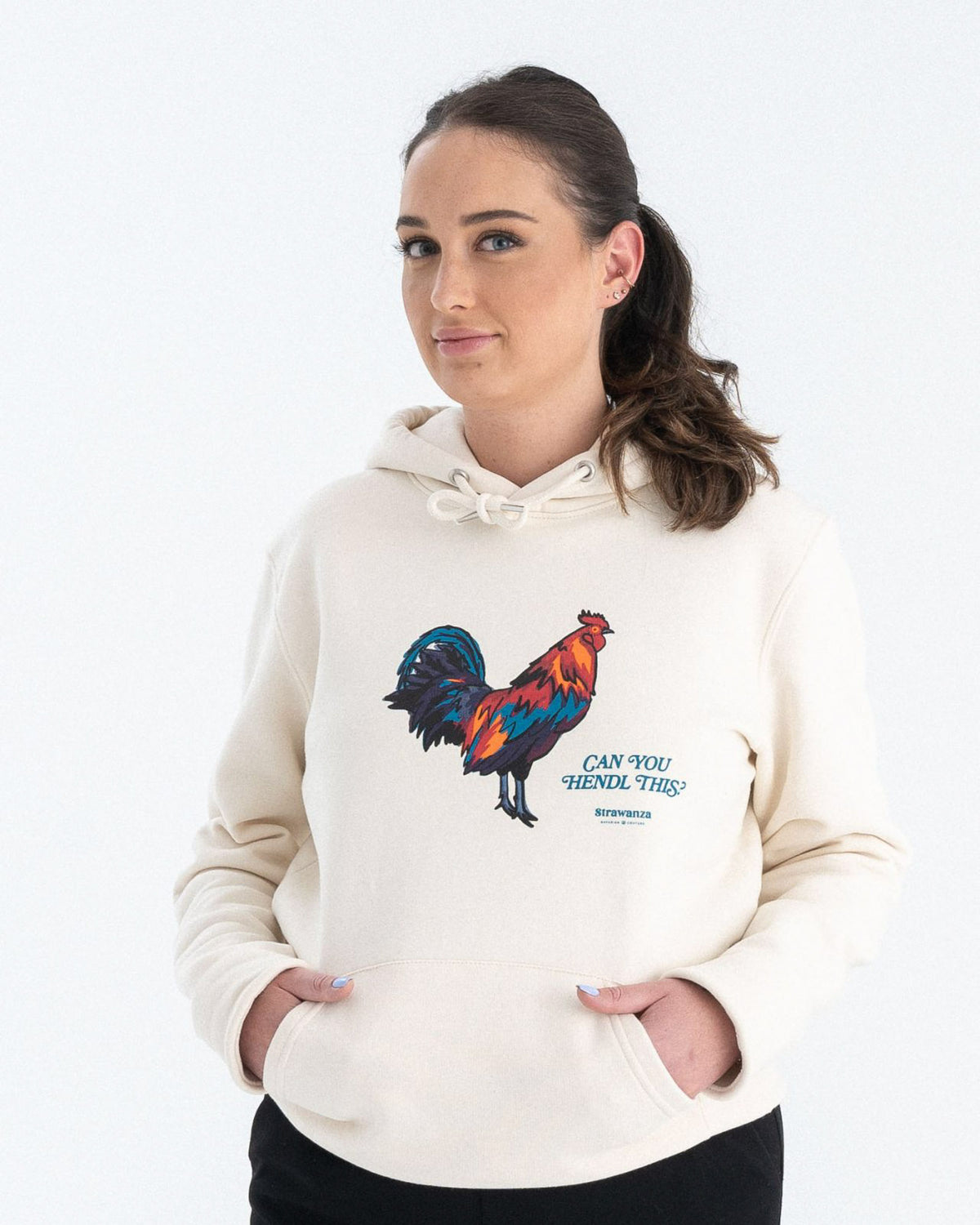 Entdecken Sie den stylischen 'CAN YOU HENDL THIS HOODIE' von Strawanza, ideal für Party-Abenteuer. Das Model präsentiert diesen trendigen beigen Hoodie im Fotostudio. Der Hoodie zeichnet sich durch sein starkes Motiv und den Siebdruck im Retro Stil aus. Perfekt für Berg- und Partyabenteuer. Hier am weiblichen Model zu sehen