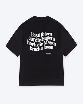 Ein schwarzes T-Shirt mit einem weißen "Festl feiern auf die Bayern hoch die Massn kracha lassn" Schriftzug als  Backprint Motiv. 