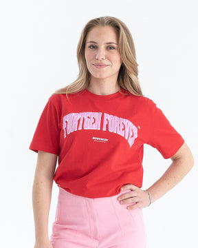 Eine Frau trägt ein rotes T-Shirt mit einem rosa "FURTGEH FOREVER" Schriftzug vorne auf der Brust als Vordermotiv. 