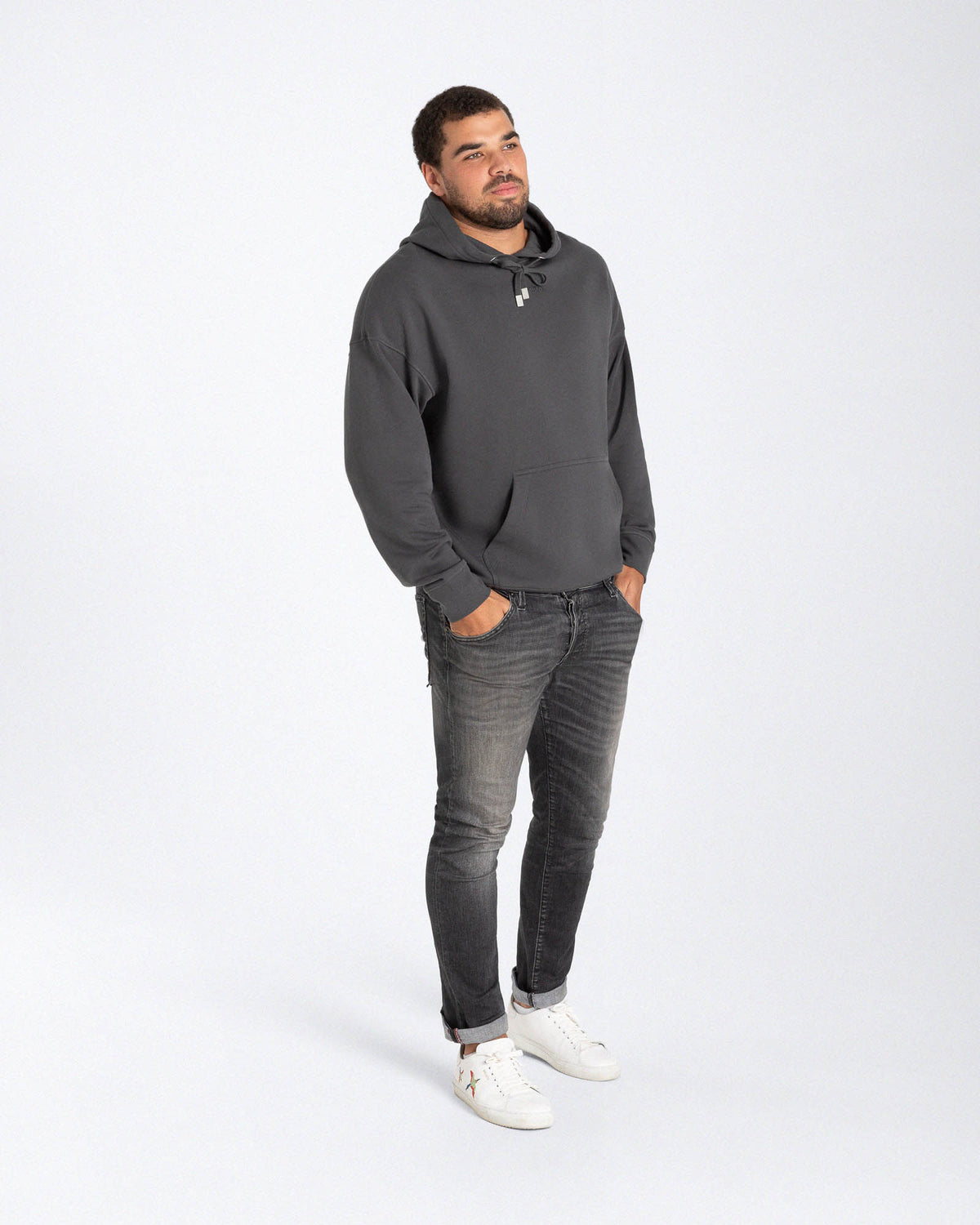 Ein männliches Model trägt einen dunkelgrauen Hoodie mit einem in Ton besticktem "Strawanza" Schriftzug auf der Höhe der Brust.