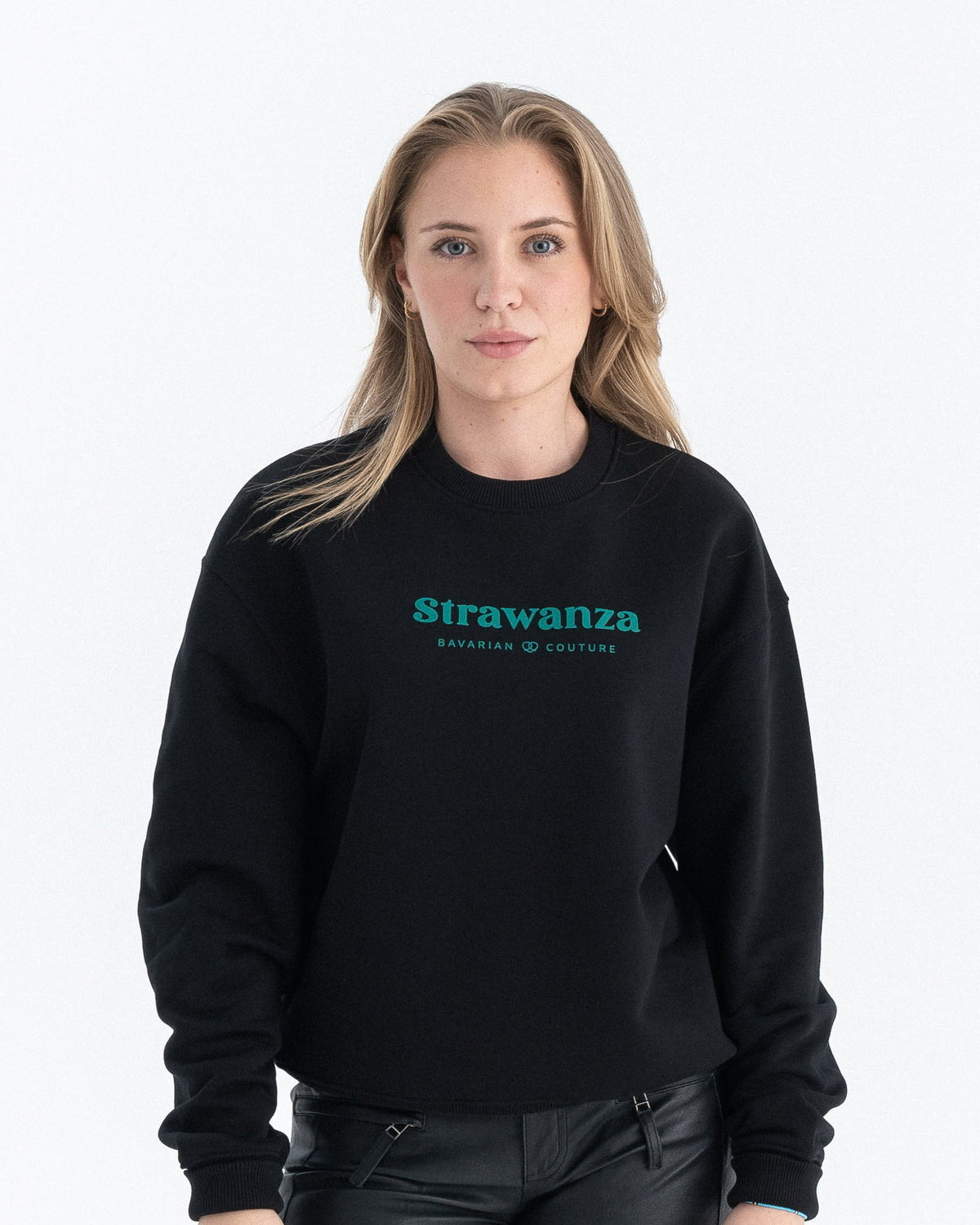 Ein weibliches Model trägt einen schwarzen Sweater mit einem dunkelgrünen "Strawanza" und "BAVARIAN COUTURE" Schriftzug auf der Höhe der Brust.