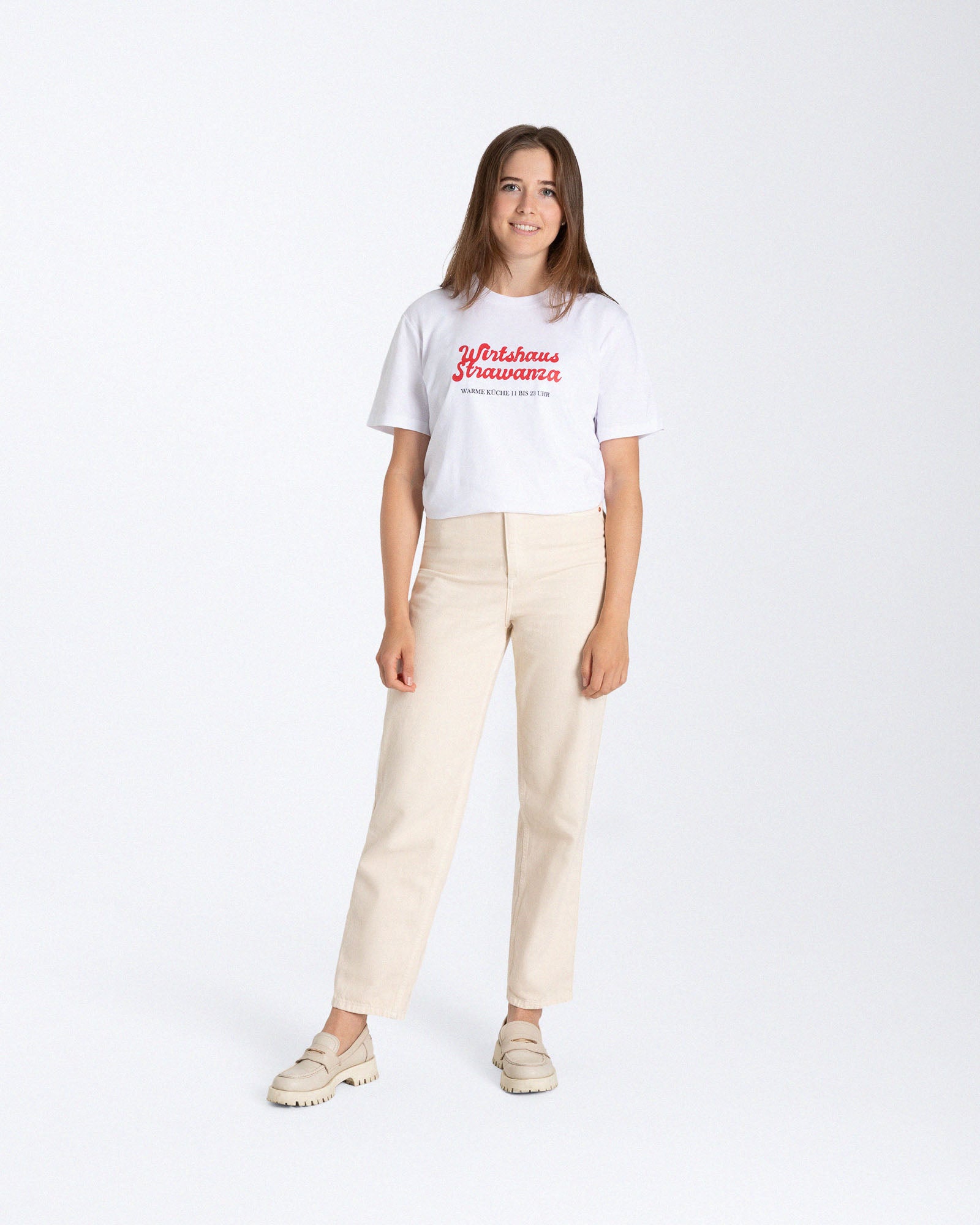 Ein weibliches Model trägt ein weißes T-Shirt mit einem zweiteiligen Print auf der Vorderseite, denn einmal ein orangener 