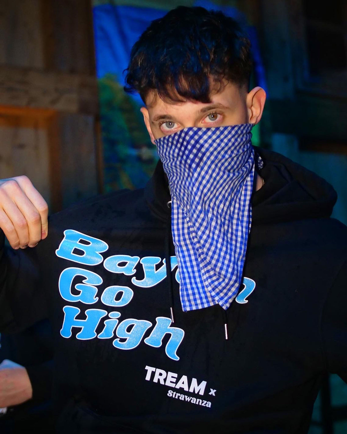 TREAM trägt einen schwarzen Hoodie mit einem "Bayern Go High" Schriftzug in der Farbe hellblau auf der Brust in Kooperation mit Strawanza.