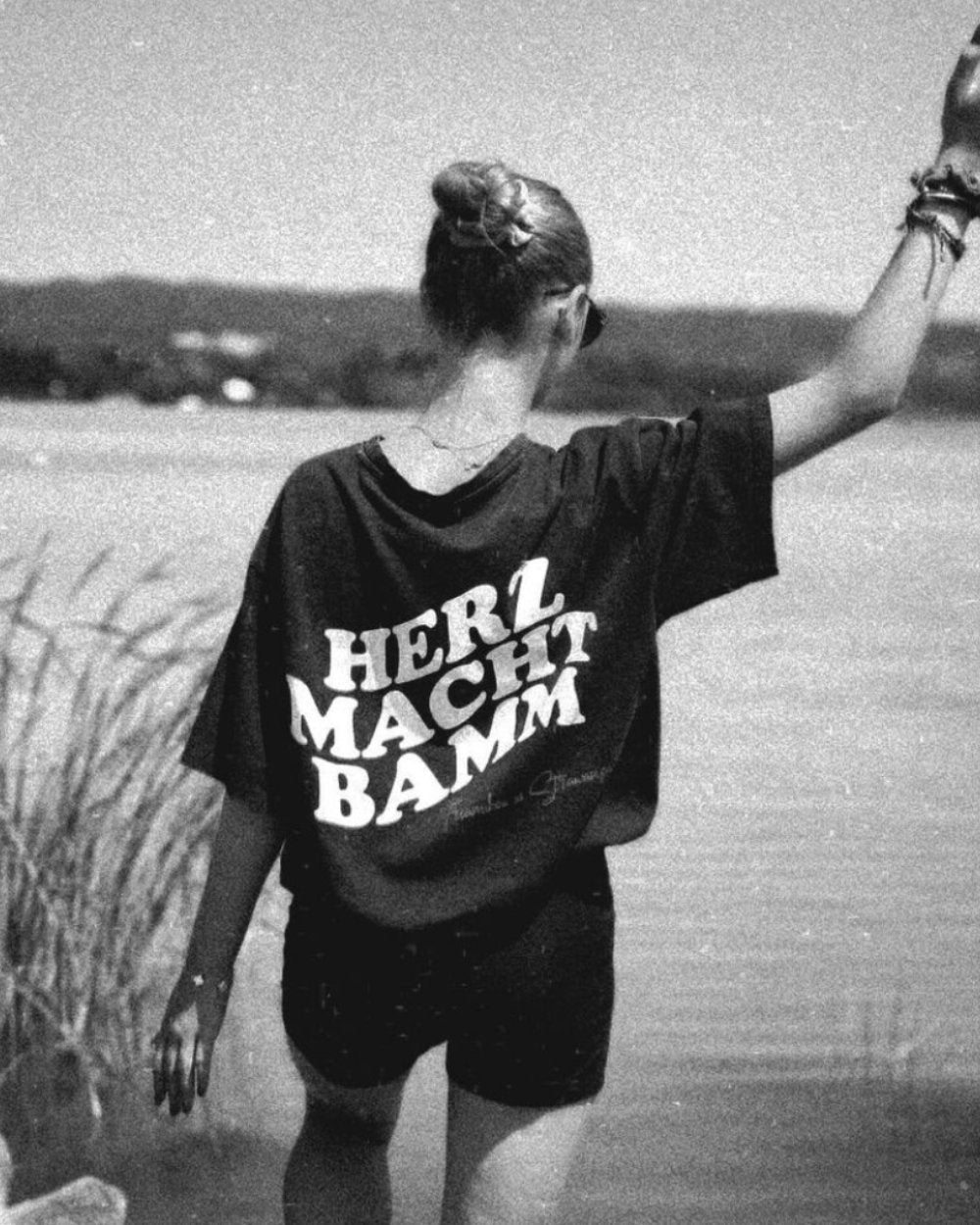 Junge Frau trägt T-Shirt aus der Kollektion von Schlagerrapper Tream x Strawanza mit "Herz macht Bamm" Aufschrift.