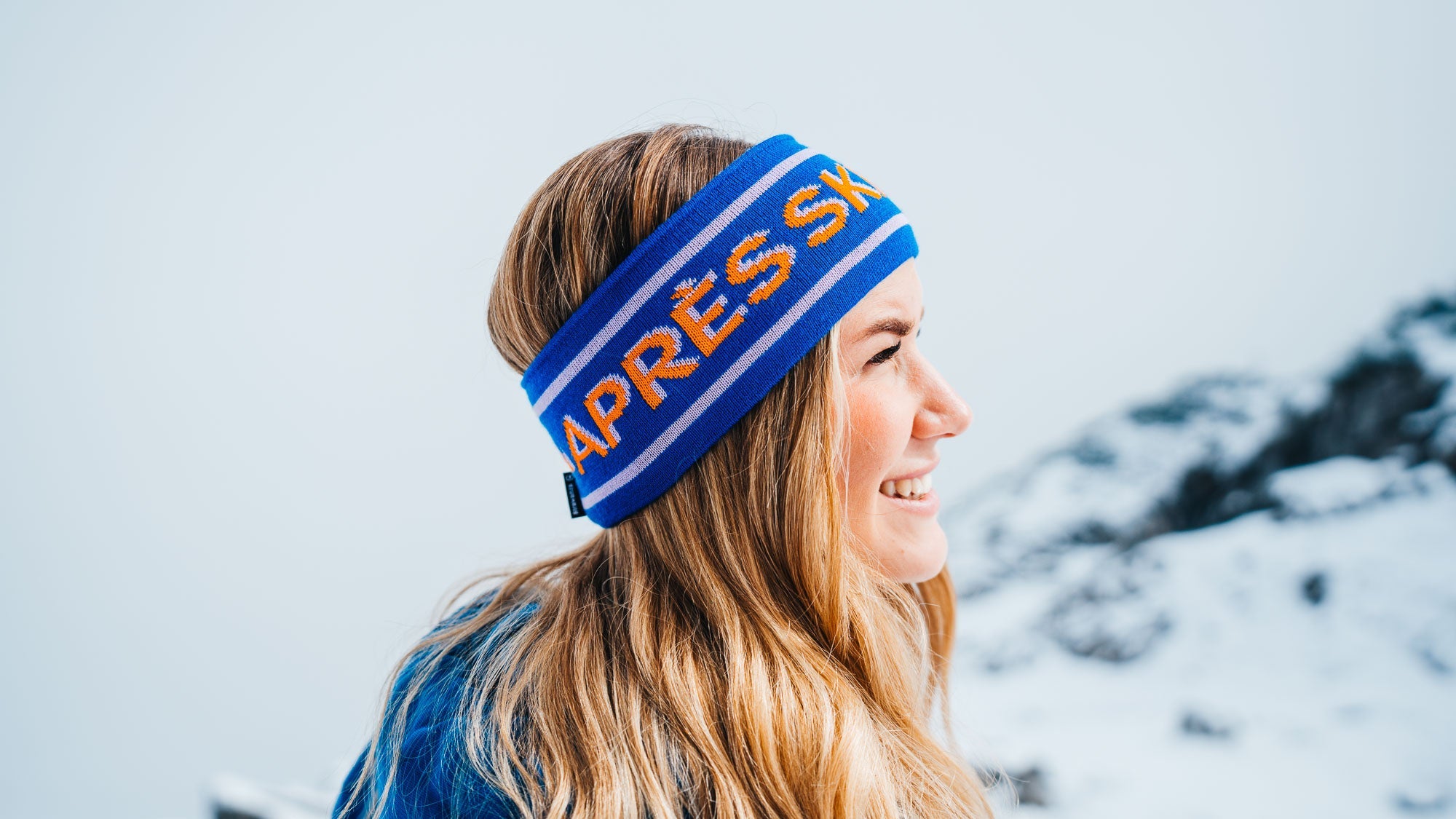 Junge Frau in einer Bergkulisse mit sportlichem Stirnband der Modemarke Strawanza.