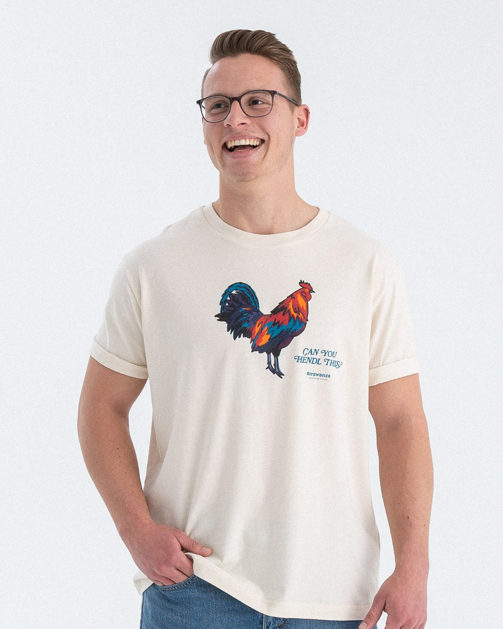 Entdecken Sie das stylische 'CAN YOU HENDL THIS T-SHIRT' von Strawanza, ideal für Party-Abenteuer. Das Model präsentiert dieses trendige beige T-Shirt im Fotostudio. Das T-Shirt zeichnet sich durch sein starkes Motiv  und den Siebdruck im Retro Stil aus. Perfekt für Berg- und Partyabenteuer und Hühnerliebhaber. Hier am Männermodel zu sehen