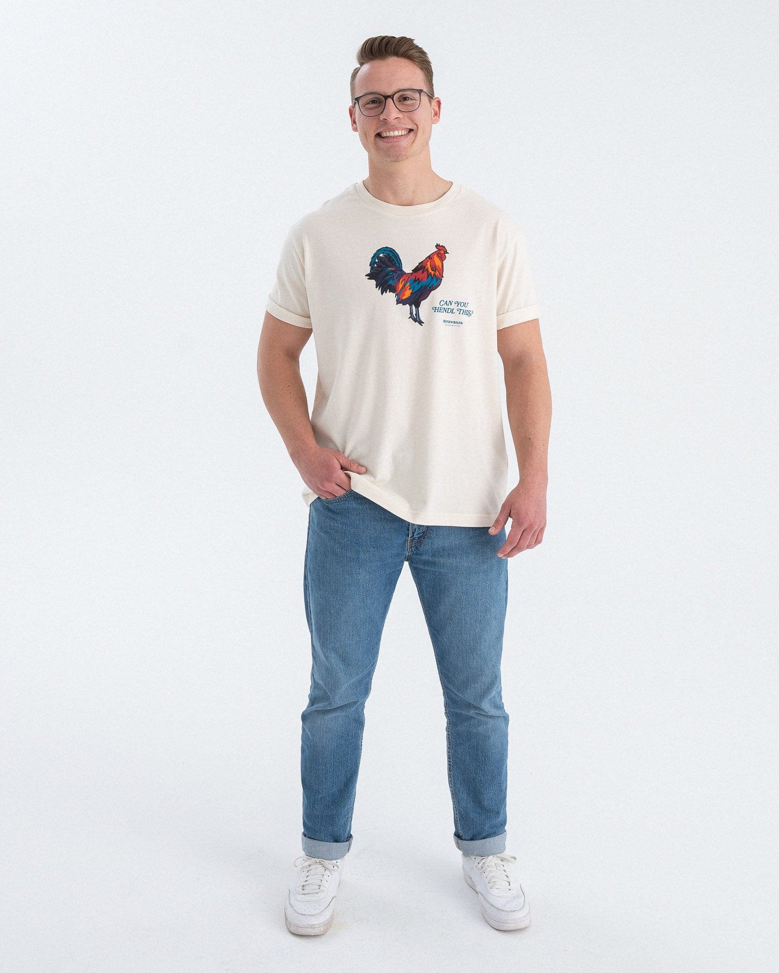 Entdecken Sie das stylische 'CAN YOU HENDL THIS T-SHIRT' von Strawanza, ideal für Party-Abenteuer. Das Model präsentiert dieses trendige beige T-Shirt im Fotostudio. Das T-Shirt zeichnet sich durch sein starkes Motiv  und den Siebdruck im Retro Stil aus. Perfekt für Berg- und Partyabenteuer und Hühnerliebhaber. Hier am Produktbild zu sehen
