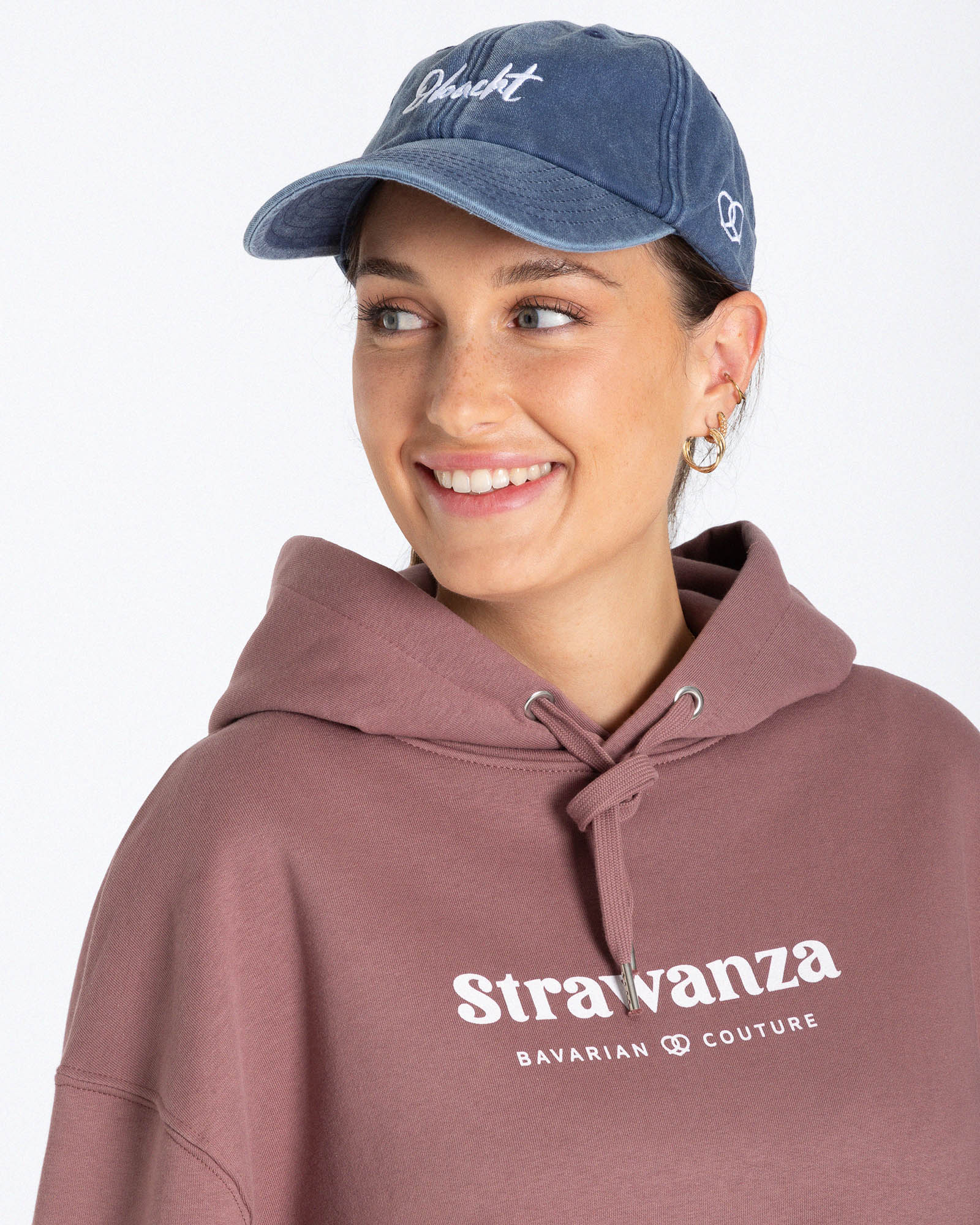 Ein weibliches Model trägt eine Bavarian Cap in der Farbe Vintage Denim und hat als Motiv vorne auf der Cap einen weißen "Obacht" Schriftzug.