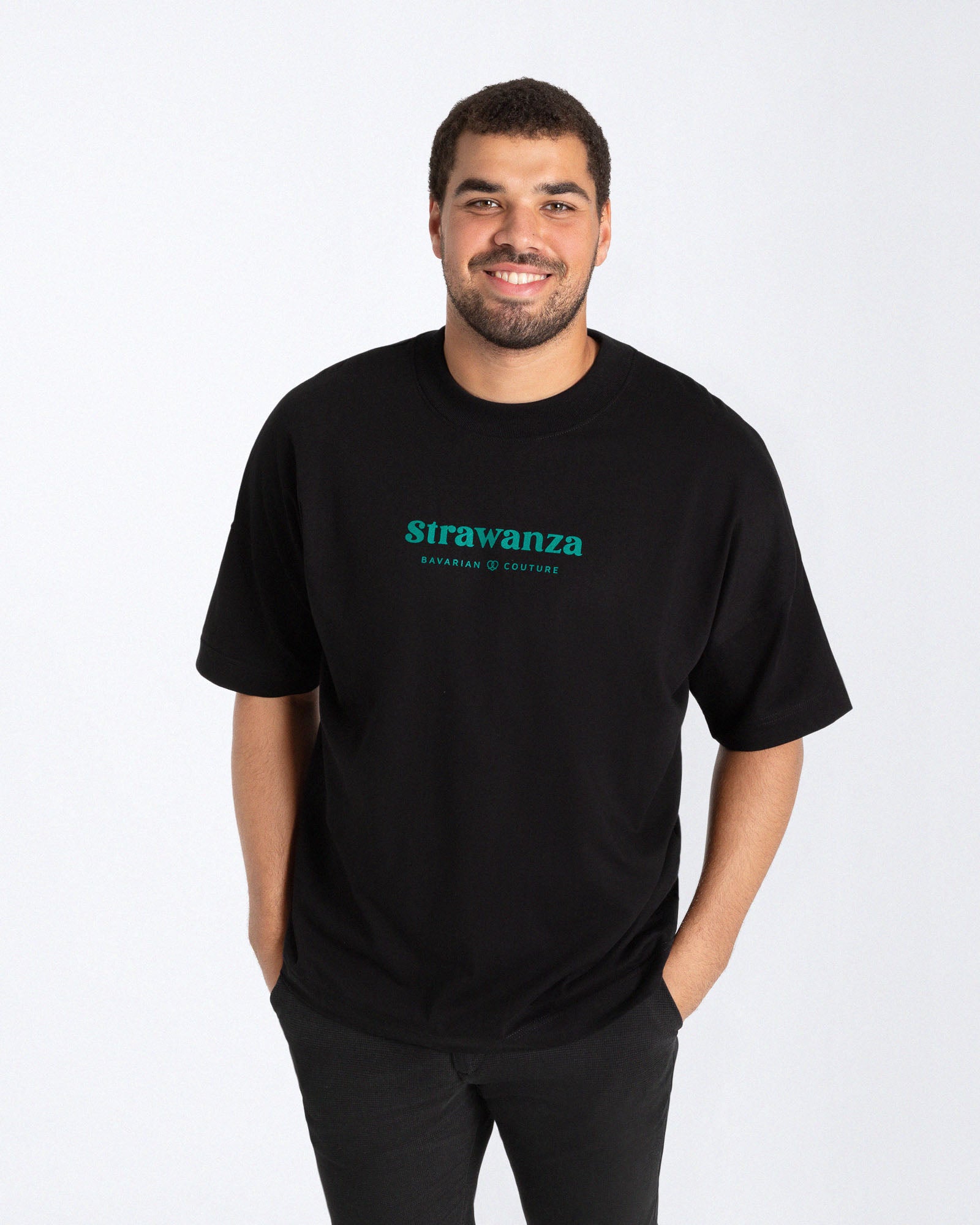 Männliches Model trägt ein schwarzes T-Shirt mit dunkelgrüner Schrift auf der Brust. 