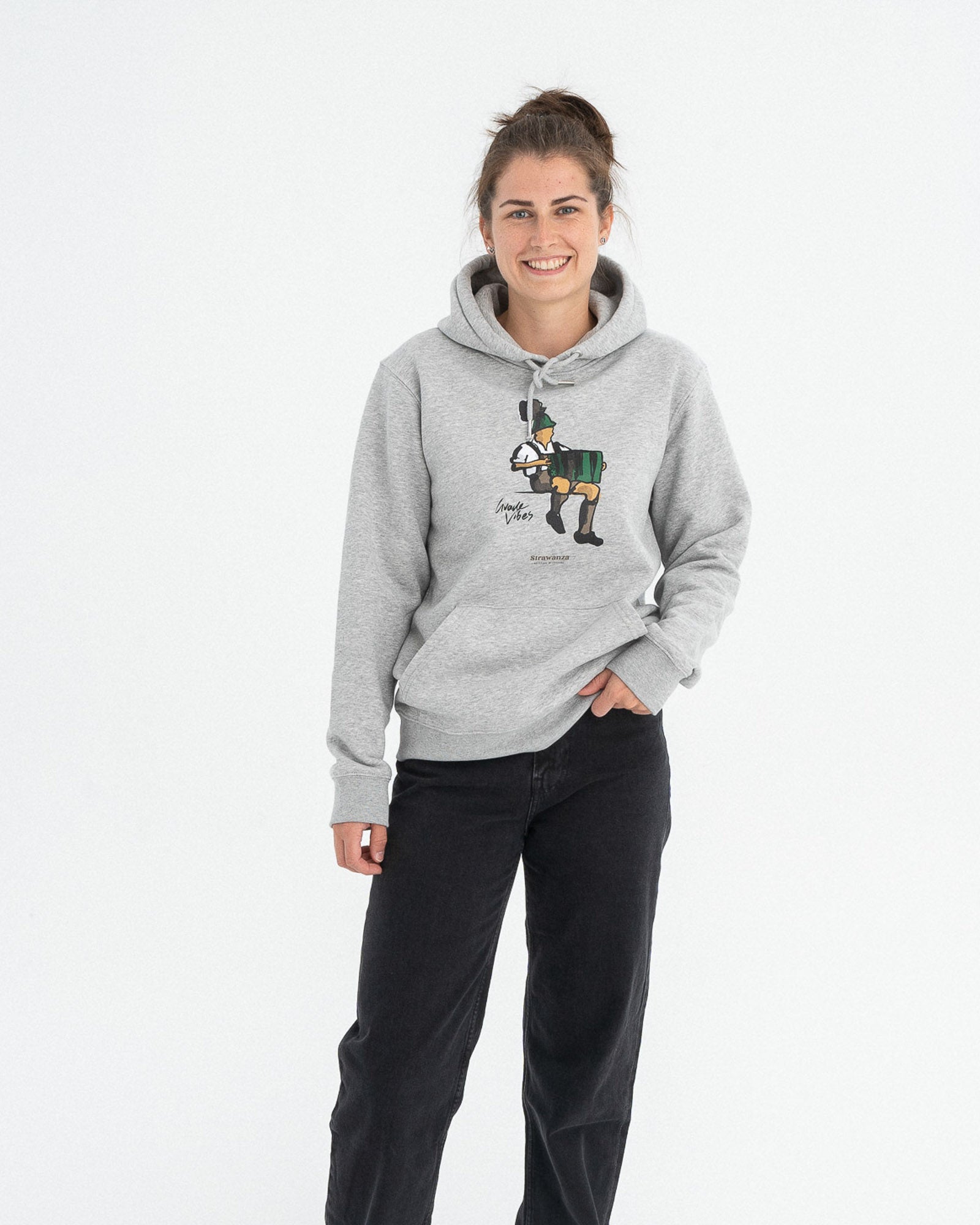 Ein weibliches Model trägt einen grauen Hoodie wo als Motiv ein Mann der Akkordeon spielt und ein schwarzer "Guade Vibes" Schriftzug zu erkennen ist.