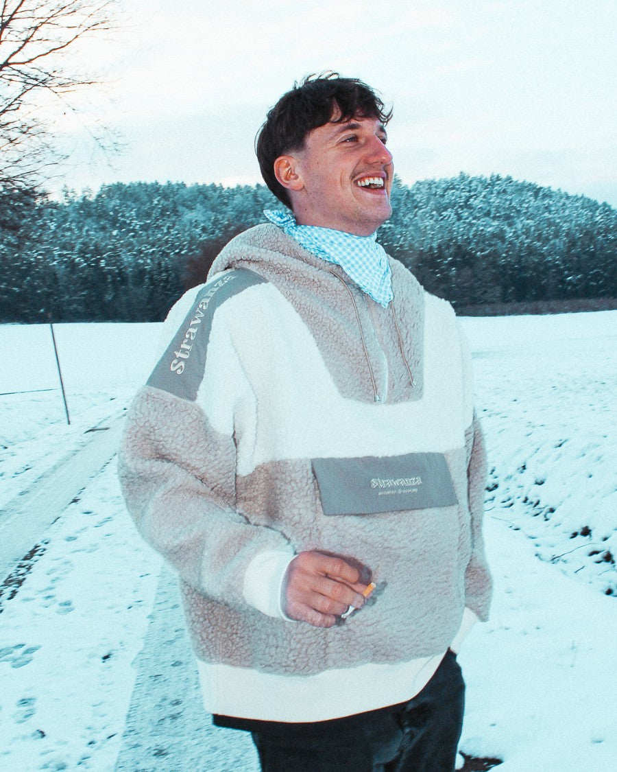 Schlagerrapper Tream trägt Fleecejacke von Strawanza Bavarian Couture in Alpenkulisse. 